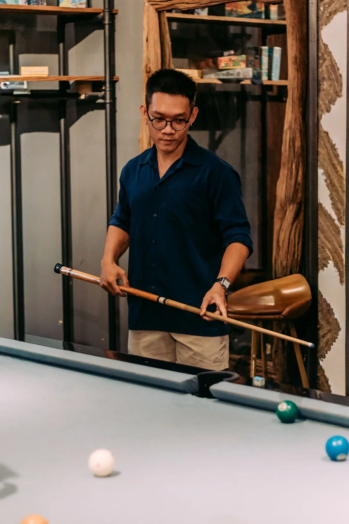 Người chơi cầm cơ đứng cạnh bàn bida